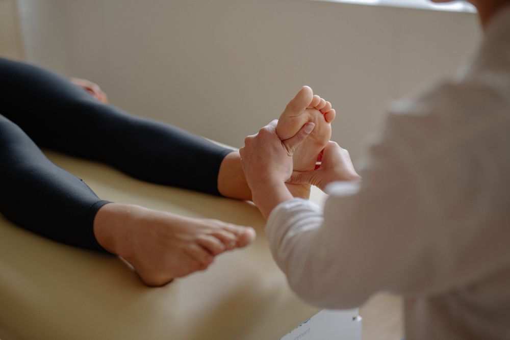 Illustrative hands applying focused pressure to a foot